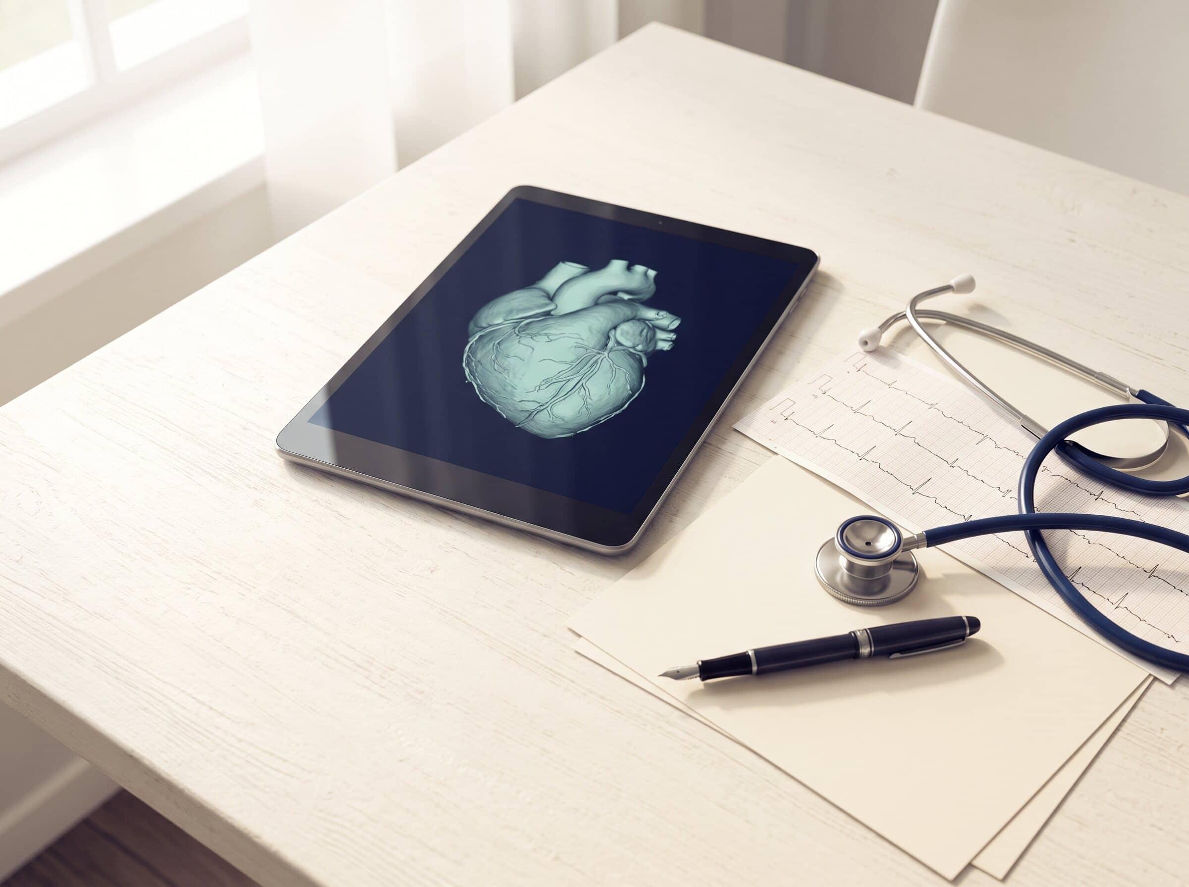 A cardiologist's desk with a tablet showing an abstract coronary CT reconstruction, an ECG strip and a stethoscope